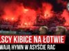 Polscy kibice na Łotwie śpiewają hymn w asyście rac (10.10.2019 r.)