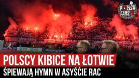 Polscy kibice na Łotwie śpiewają hymn w asyście rac (10.10.2019 r.)